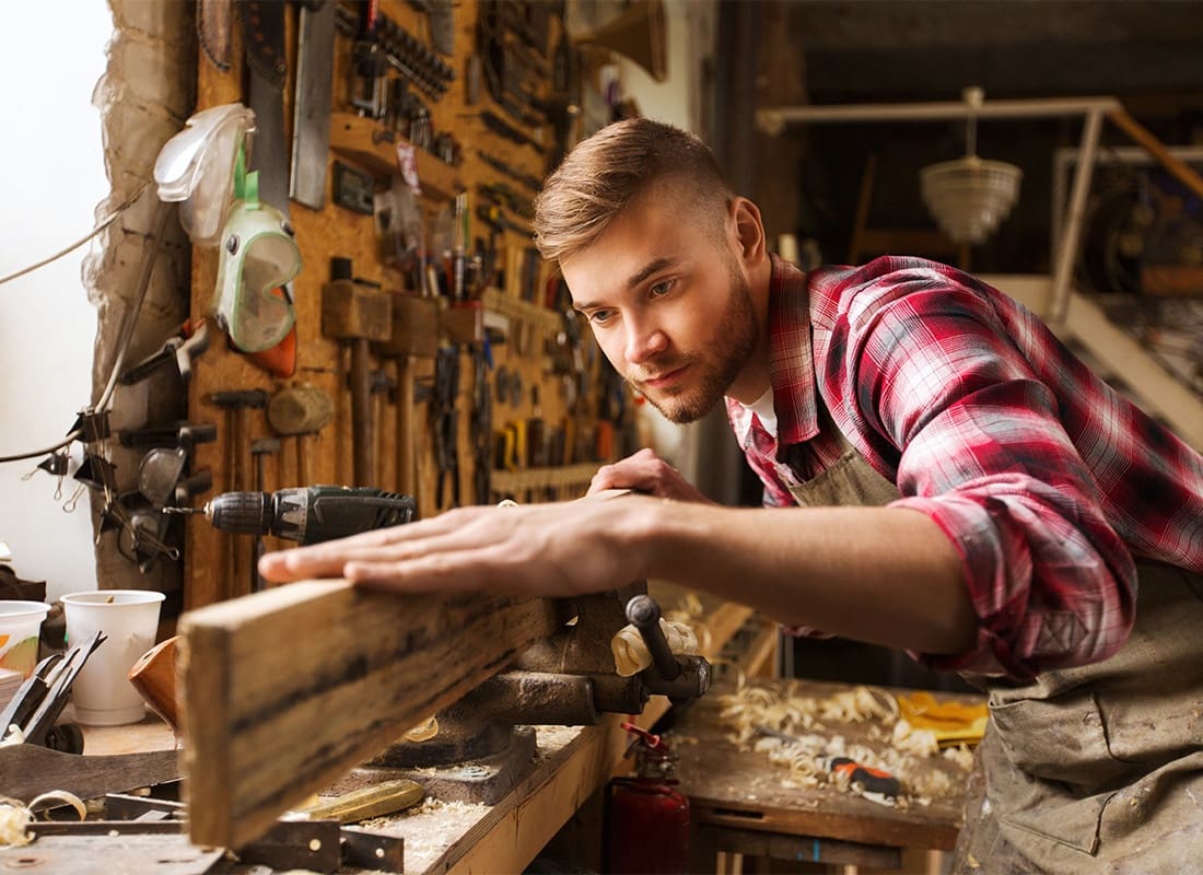 Insurance by Industry - Carpentar Carving Wood in His Workshop